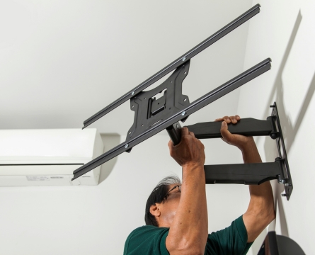 Técnico instalando un televisor en soporte de pared en Bogotá